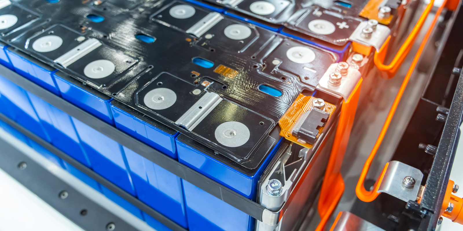 Close-up of a modern lithium-ion battery pack with blue cells and orange cooling lines used in electric vehicles and energy storage.
