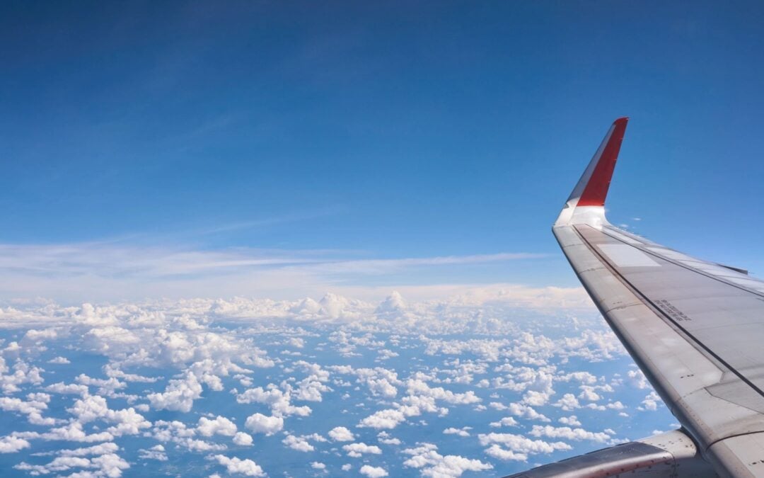 Airplane wing in sky of clouds